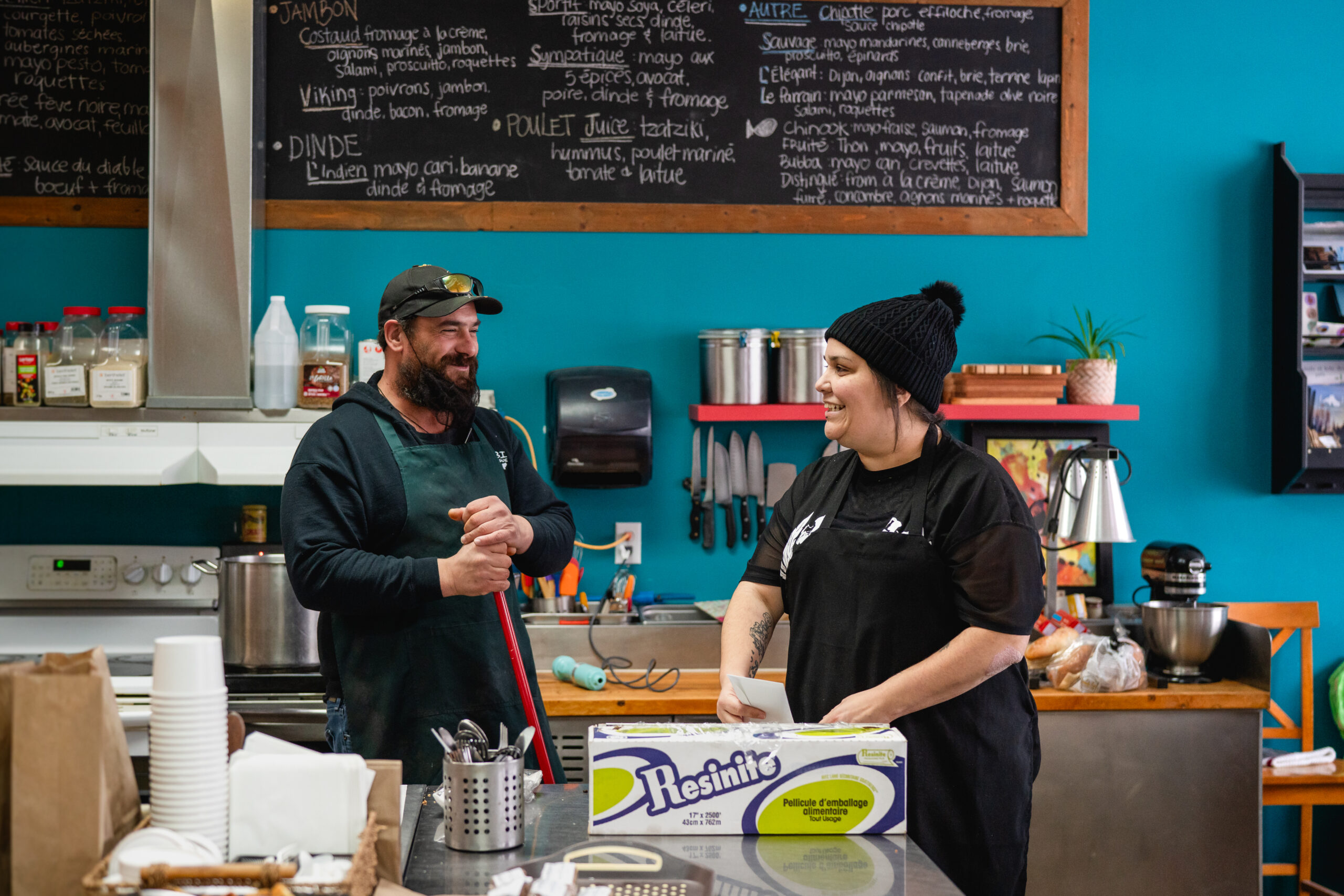 Un participant et une animatrice souriants dans la cuisine.